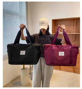 Vue detaillee montrant les caracteristiques du sac de voyage impermeable et ses poignees.