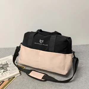 Durable travel duffel bag with shoulder strap, black and pink color block for outdoor fitness.