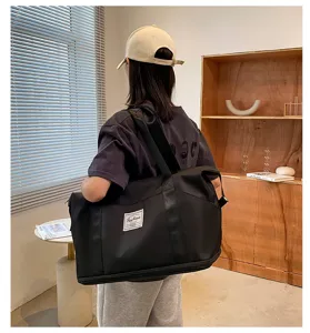 Détail du grand sac de voyage noir, idéal pour le sport, la salle de gym et les week-ends.