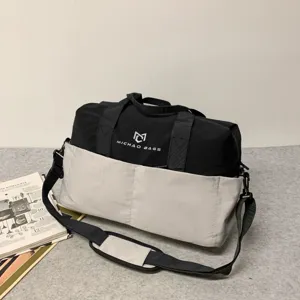 Detailed view of the black and grey travel duffel bag showing durable fabric and front pocket.