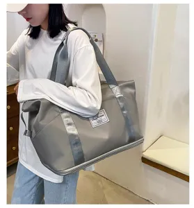 Vue détaillée d'un grand sac de voyage de sport étanche gris avec sangle et poignée.