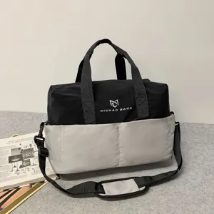 Detailed view of the black and grey travel duffel bag featuring sturdy straps and brand logo.
