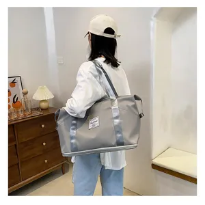 Grand sac de voyage imperméable avec sangles argentées pour le sport et les déplacements.
