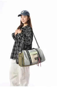 Detailed view of large capacity duffel travel bag with stylish color blocking and shoulder strap.