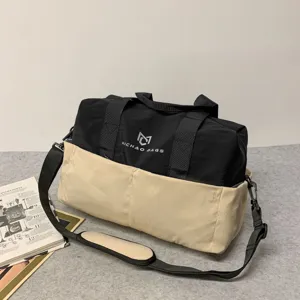 Black and beige travel duffel bag detail, durable canvas gym bag with adjustable shoulder strap.