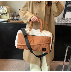 Color-blocked travel duffel bag with soft fabric, top handles and adjustable shoulder strap.