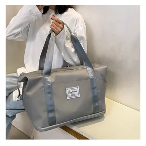 Vue de detail d'un grand sac de voyage gris avec tissu impermeable et compartiment inferieur.