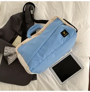 Color-blocking travel duffel bag detail, soft canvas shoulder bag for commuting and trips.