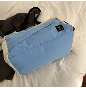 Blue and beige color block travel duffel bag with shoulder strap for sports, gym and commuting.