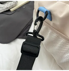 Close-up detail of the black bag shoulder strap with adjustable buckle and hook.