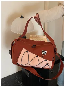 Detailed view of the large capacity stylish color-block shoulder bag with bungee cords.