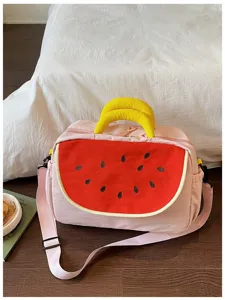 Dettaglio borsa da viaggio con ricamo anguria, tela rosa con manici gialli vivaci.