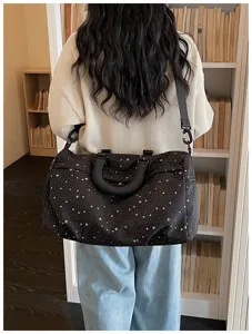 Detailed view of large black travel duffel bag with stylish white star print design.