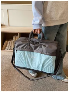 Detailed shot of large capacity travel duffel bag with shoulder strap and dual-tone design.