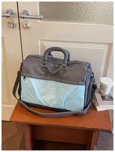 Large capacity travel duffel bag with shoe compartment and adjustable shoulder strap.