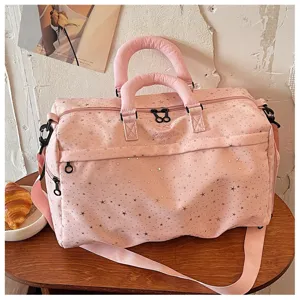 Close-up detail of the pink star-printed travel duffel bag showcasing texture and dual handles.