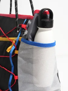 Multifunctional outdoor sports travel bag with mesh side pocket and colorful bungee cord.