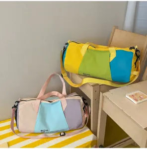 Dettaglio borsa da viaggio colorata con doppie maniglie e tessuto resistente e durevole.