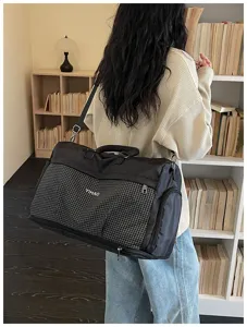 Large capacity travel duffel bag with grid front pocket, ideal for weekend trips.