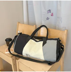 Dettaglio del borsone da viaggio bicolore, con tessuto resistente e manici molto robusti.