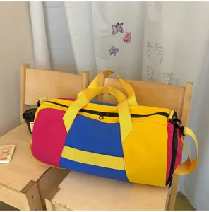 Dettaglio borsa da viaggio color-block, con tessuto giallo, blu e rosa vivace e resistente.
