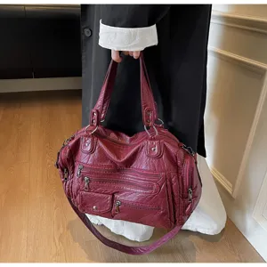 Detail view of the red washed soft leather multi-zipper motorcycle shoulder bag with large capacity.
