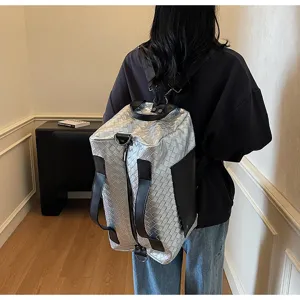Zaino da viaggio intrecciato argento, grande borsa in pelle metallizzata con bordi neri.