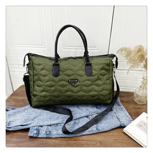 Sac de voyage matelassé vert olive avec bandoulière réglable et poignées pour bagages.