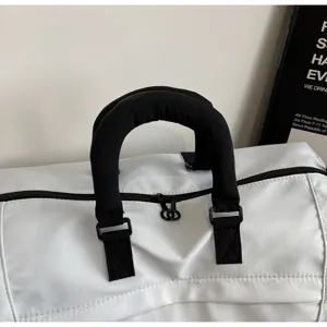 Close-up detail of travel duffel bag handle, durable black straps and smooth zipper.