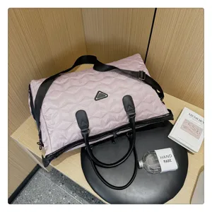 Sac de voyage matelassé rose avec poignées noires et bandoulière pour week-end.