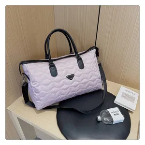 Sac de voyage matelassé rose avec poignées noires, grand sac week-end pour femmes.