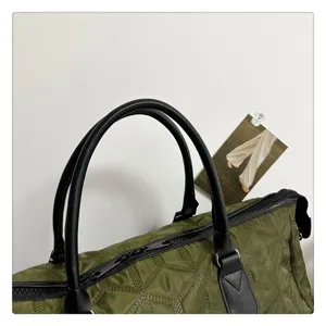 Sac de voyage matelassé vert foncé avec poignées en cuir noir vue détaillée pratique.