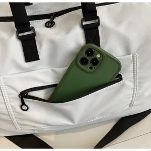Detail shot of white large capacity travel duffel bag with black straps for gym sport trips.