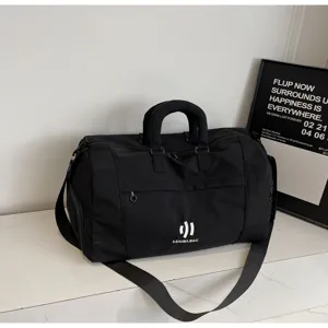 Detailed view of the large capacity black travel duffel bag with sturdy handles and strap.