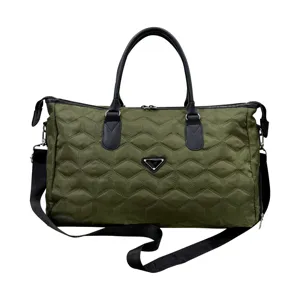 Sac de voyage matelassé vert avec poignées noires et une bandoulière réglable pour voyages.
