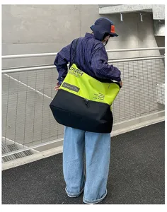 Vue détaillée du grand sac de voyage bandoulière en vert néon et noir avec grande capacité.