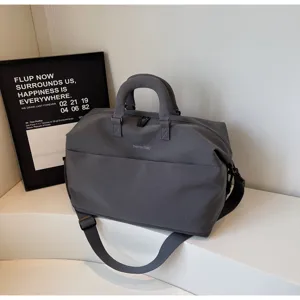 Detail view of the dark gray travel duffel bag, showing its large capacity and durable strap.