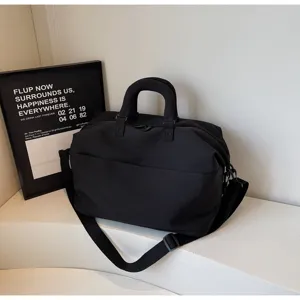 Black travel duffel bag with shoulder strap, durable fabric for short trips and daily storage.