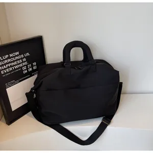 Black travel duffel bag detail, versatile business overnight luggage with shoulder strap.
