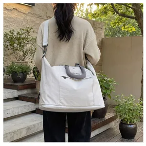 Stylish cotton travel duffel bag detail, lightweight canvas shoulder luggage for fitness and commute.