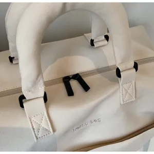 Sac de voyage en toile poignée et fermeture détail, design minimaliste et durable.
