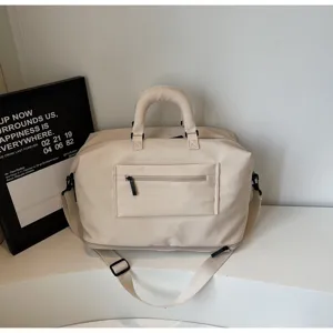 Vue détaillée du sac de voyage beige polyvalent avec poche avant et bandoulière.