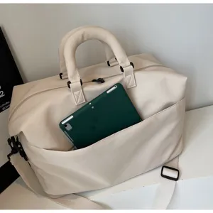 Sac de voyage minimaliste en toile avec bandoulière et poche avant pour les courts trajets.