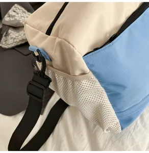 Detail view of the color-block travel duffel bag showing the mesh pocket and strap.