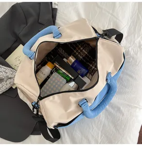 Color-block travel duffel bag with soft fabric, blue handles, and large capacity for commute.