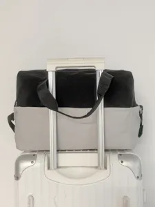 Two tone travel duffel bag mounted on luggage handle for outdoor sports and gym use.