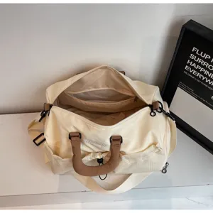 Grand sac de voyage en toile beige avec poignées marron et poche intérieure pour le sport et le fitness.