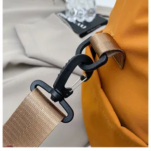 Close-up detail van stijlvolle reistasriem, duurzame hardware gesp en bruine webbing.