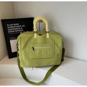 Detailed view of the large capacity green travel duffel bag with front zipper pocket and straps.
