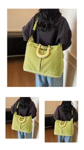 Detailed view of the green canvas travel duffel bag showing wearing style and design.